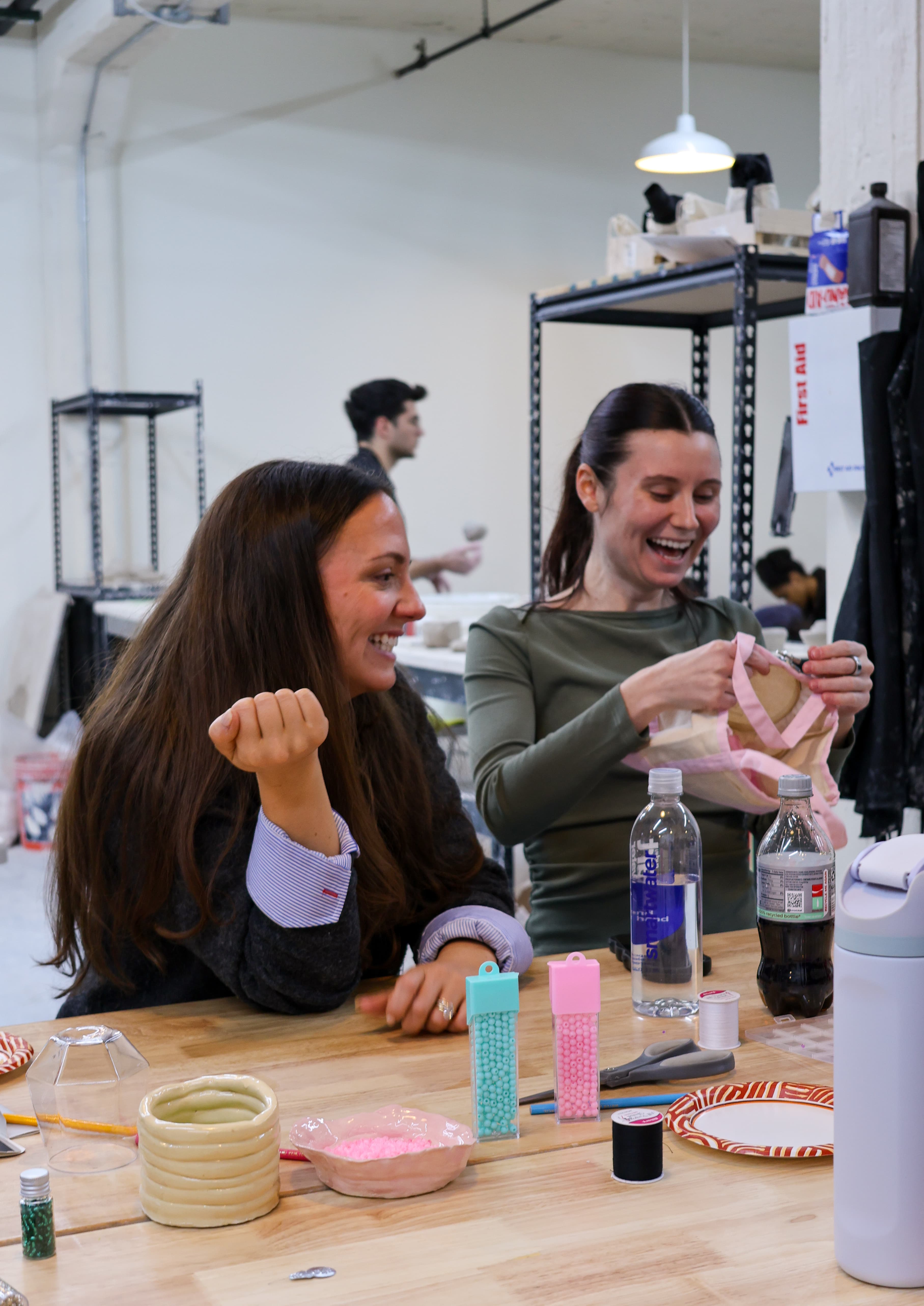 Two students laughing while working on their embroidery