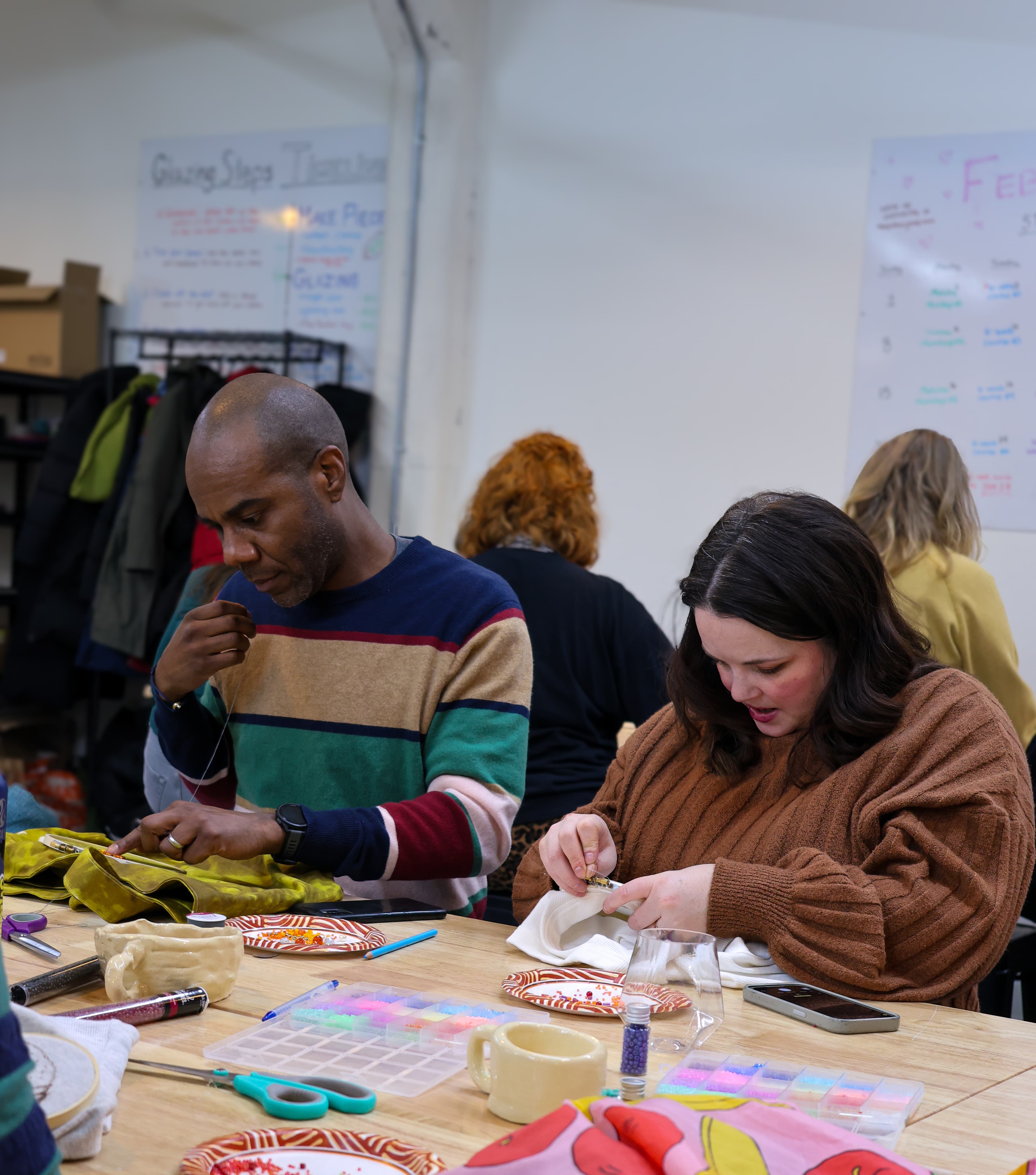 Two students working together on beaded embroidery projects
