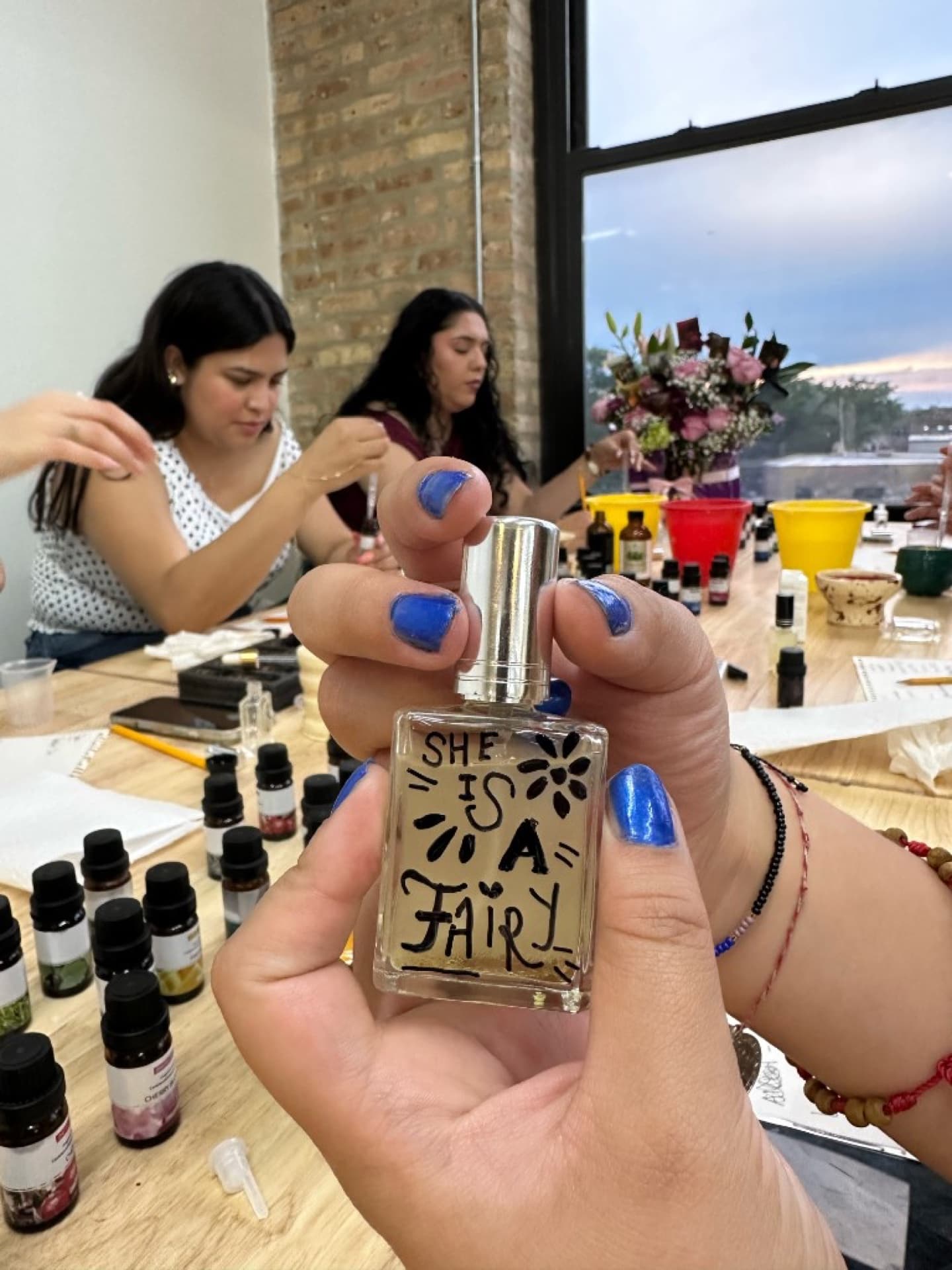Guest holding a custom perfume bottle labeled at the workshop