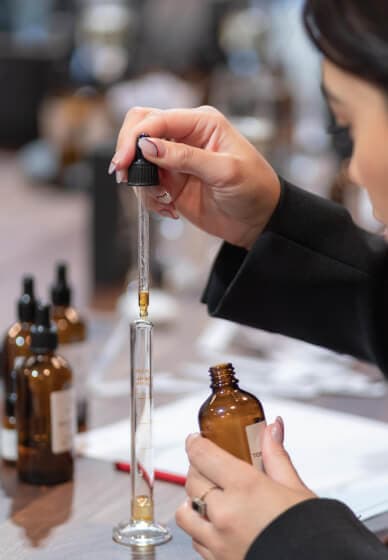 Pipette dropping fragrance accord into a glass vial