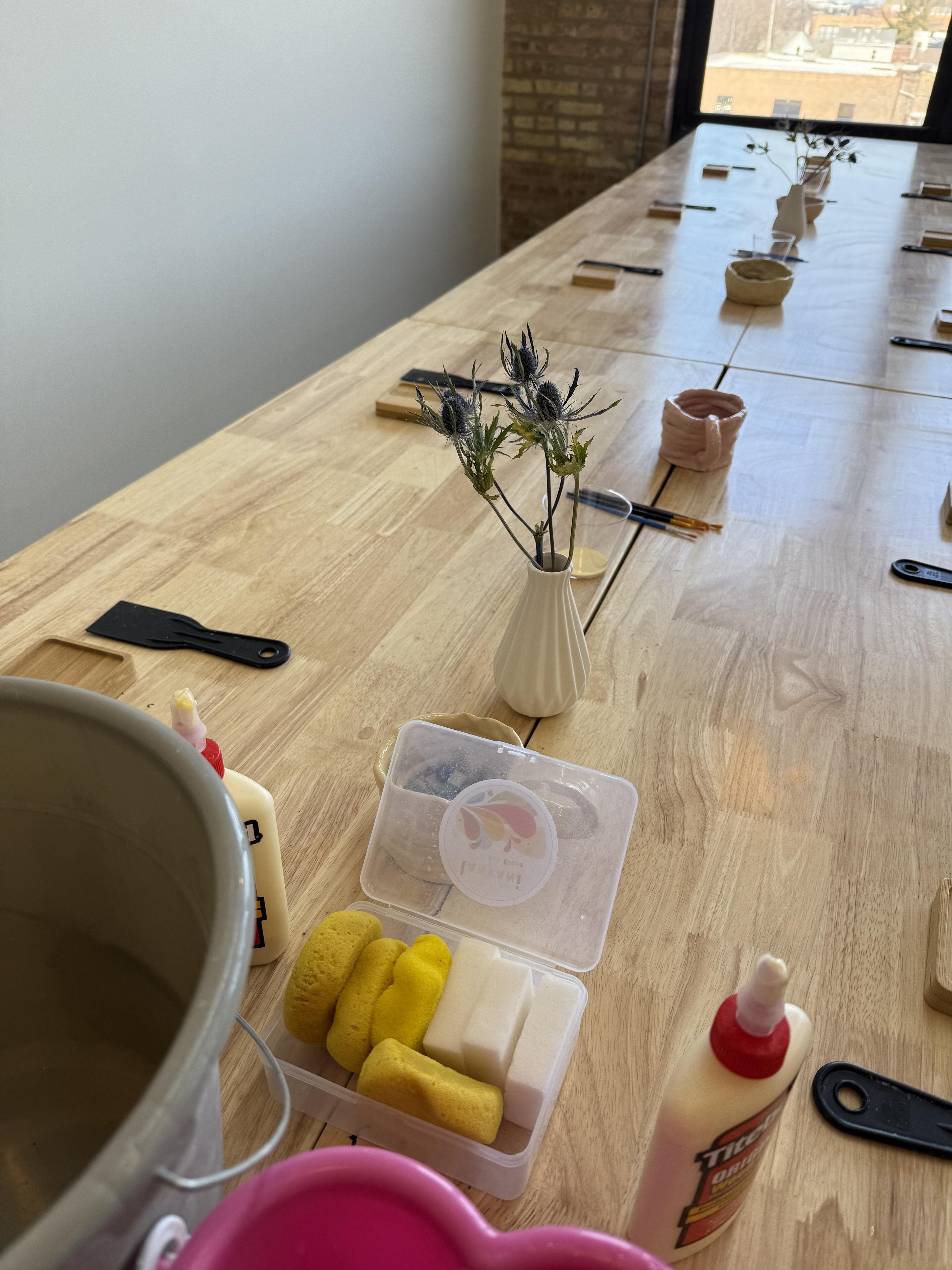 Students working on mosaic coasters at the studio table