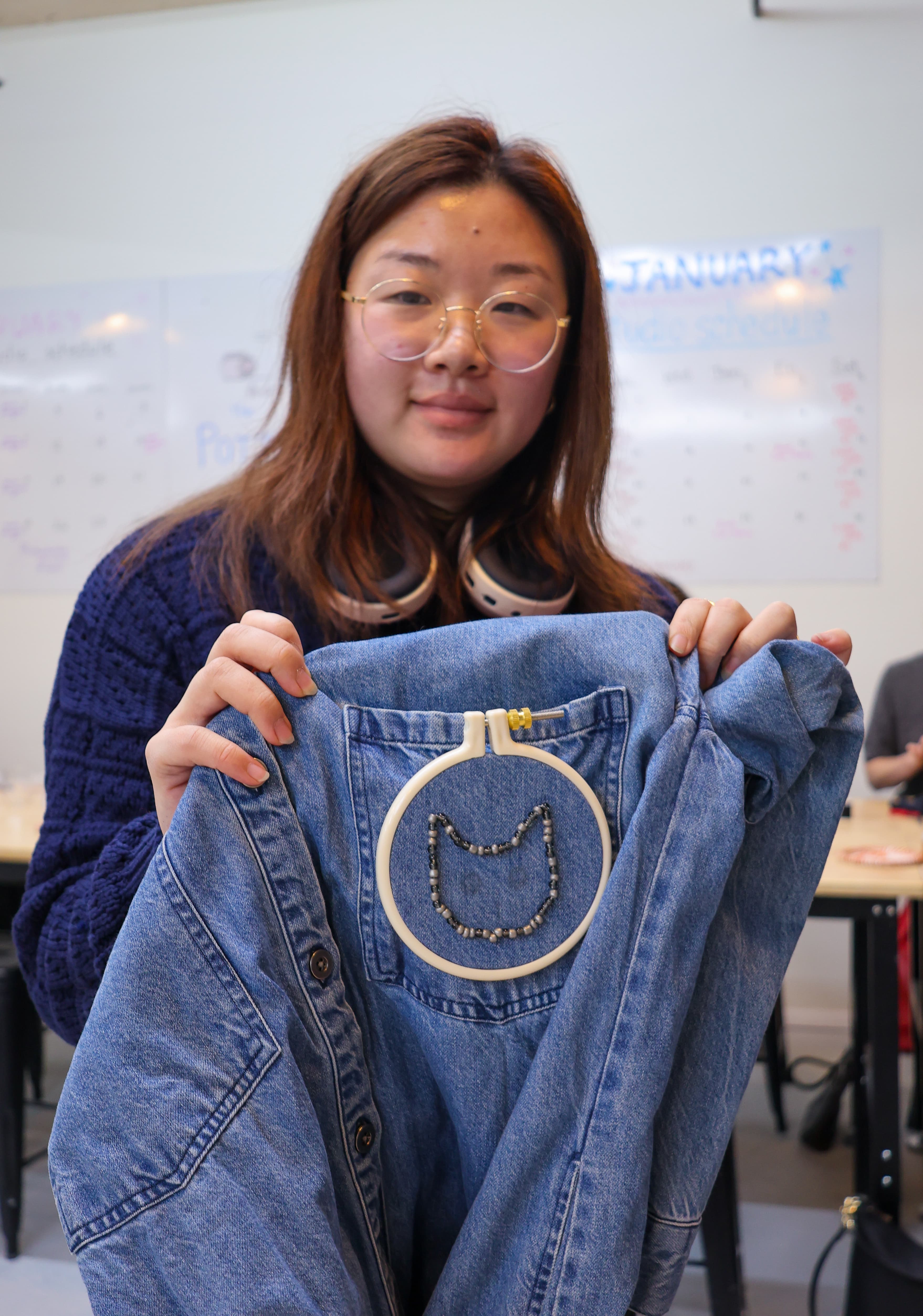 Student holding finished beaded embroidery piece